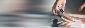 Hands flipping through printed documents