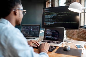 Developer working with code on multiple screens