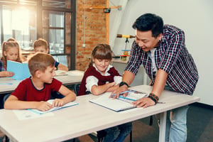Teacher supporting students with their work in class